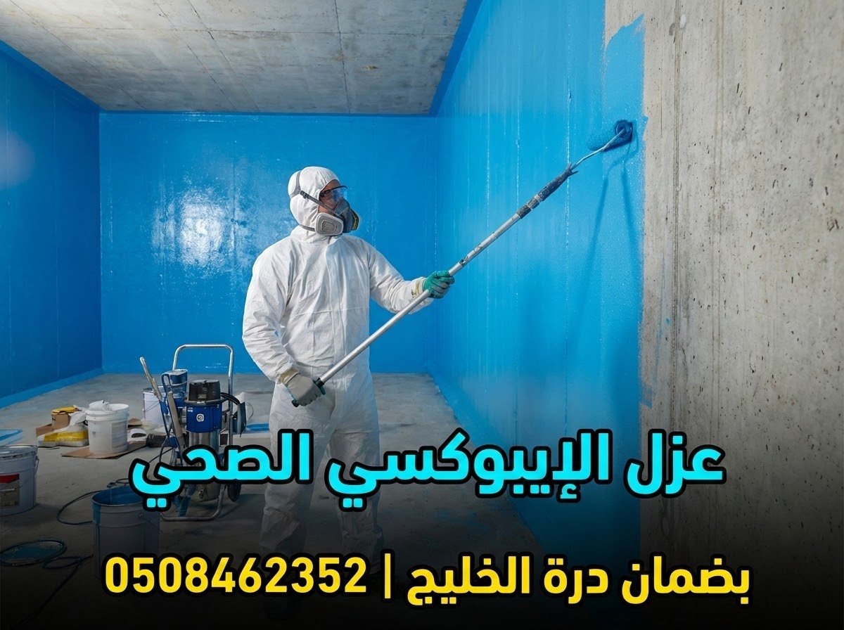 فني متخصص من شركة درة الخليج يرتدي ملابس واقية ويقوم برش مادة الإيبوكسي الزرقاء الصحية على جدران خزان مياه أرضي خرساني